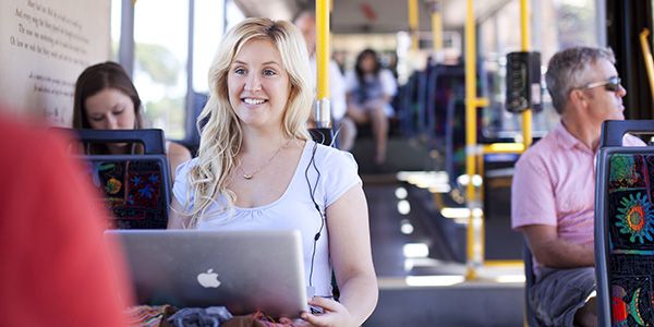 A female looking at a laptop on a Perth bus