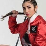 Antoinette Raphael wearing an red bomber jacket that she designed for her fashion brand RAW WAR