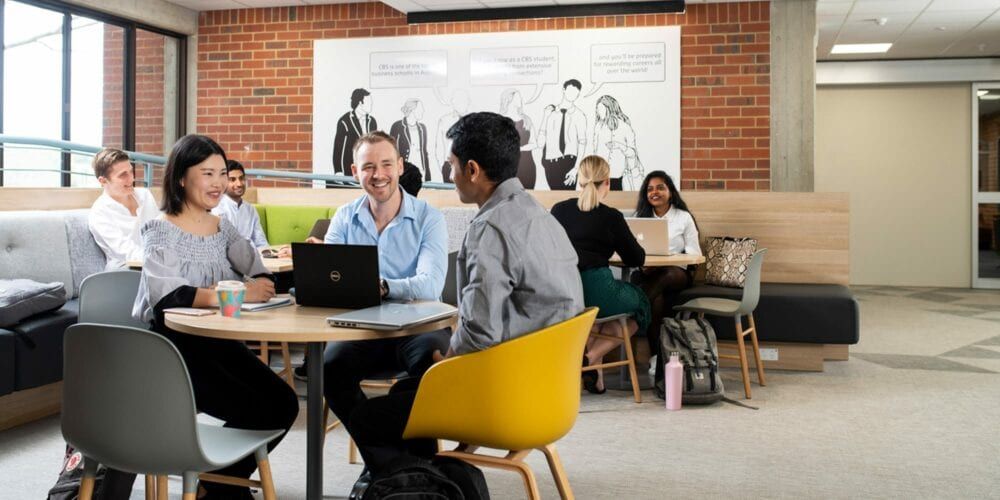 Group of students sitting at a table working on a group project