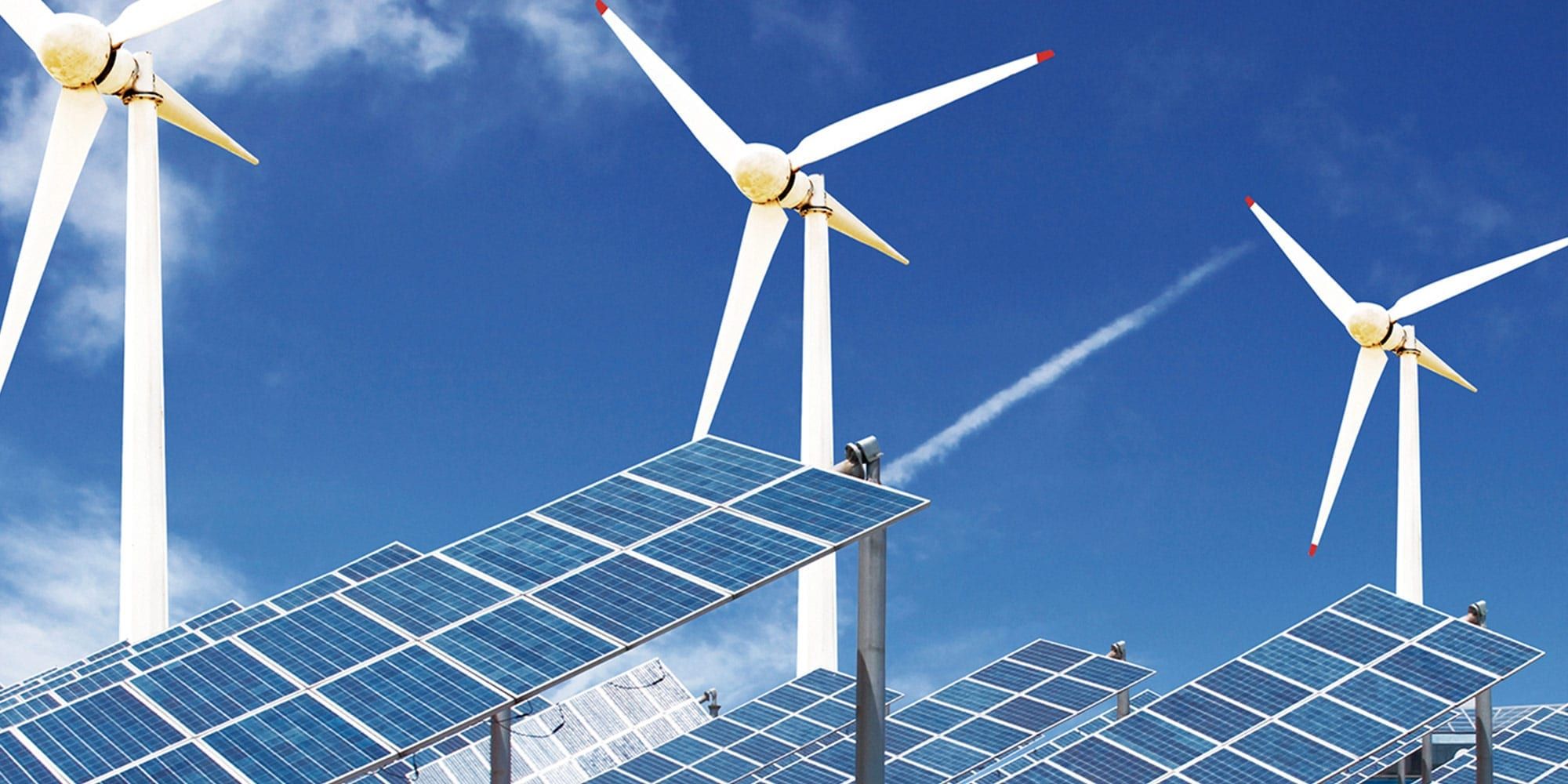 Solar panels and 3 windmills against a sky backdrop