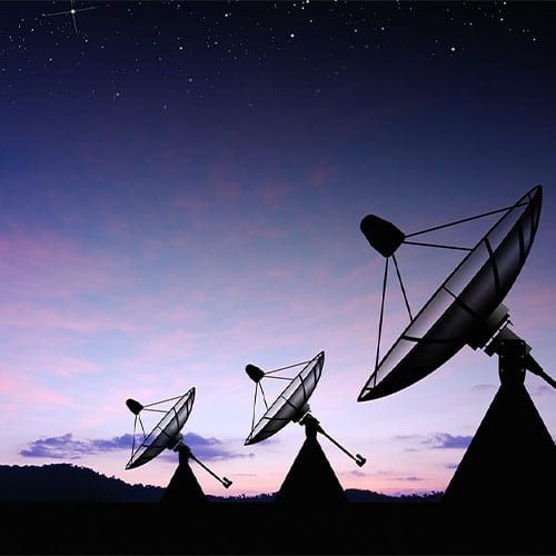 Three radio telescopes pointing towards the night sky