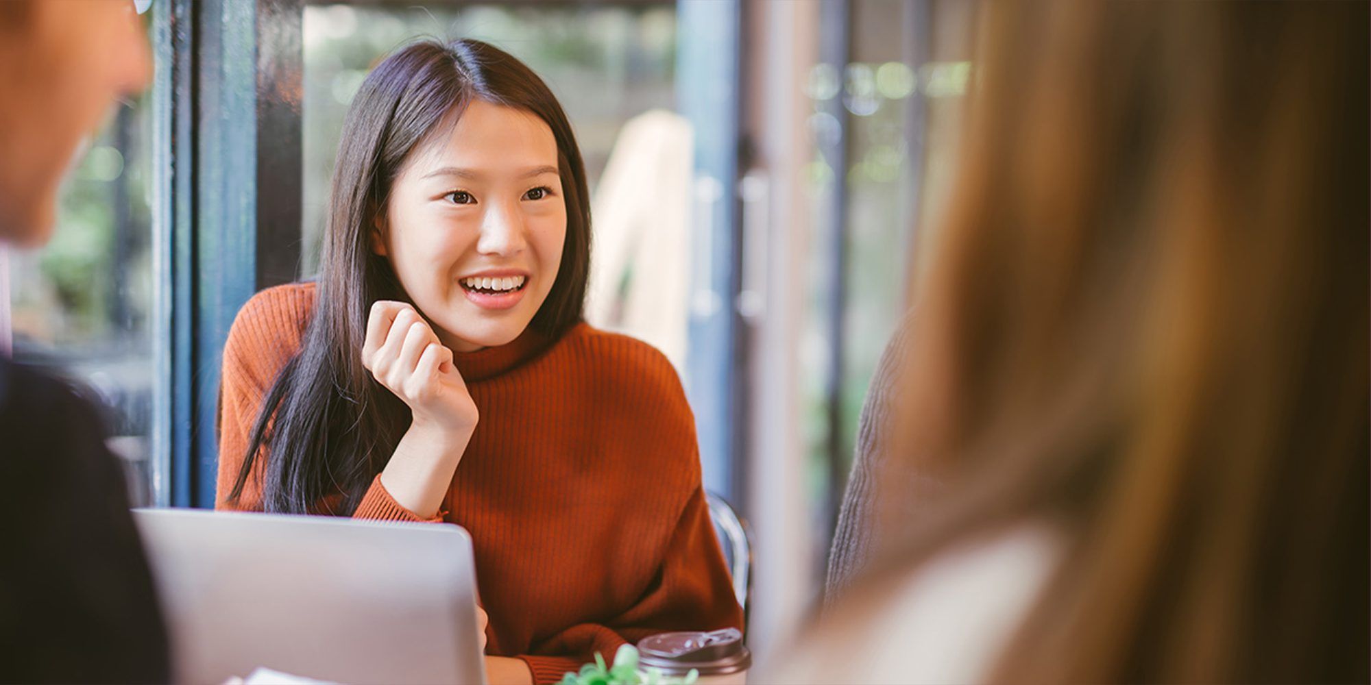 Girl speaking to friends at a desk