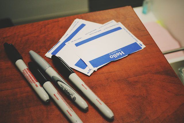 Pile of permanent markers sitting next to 'My Name Is' stickers