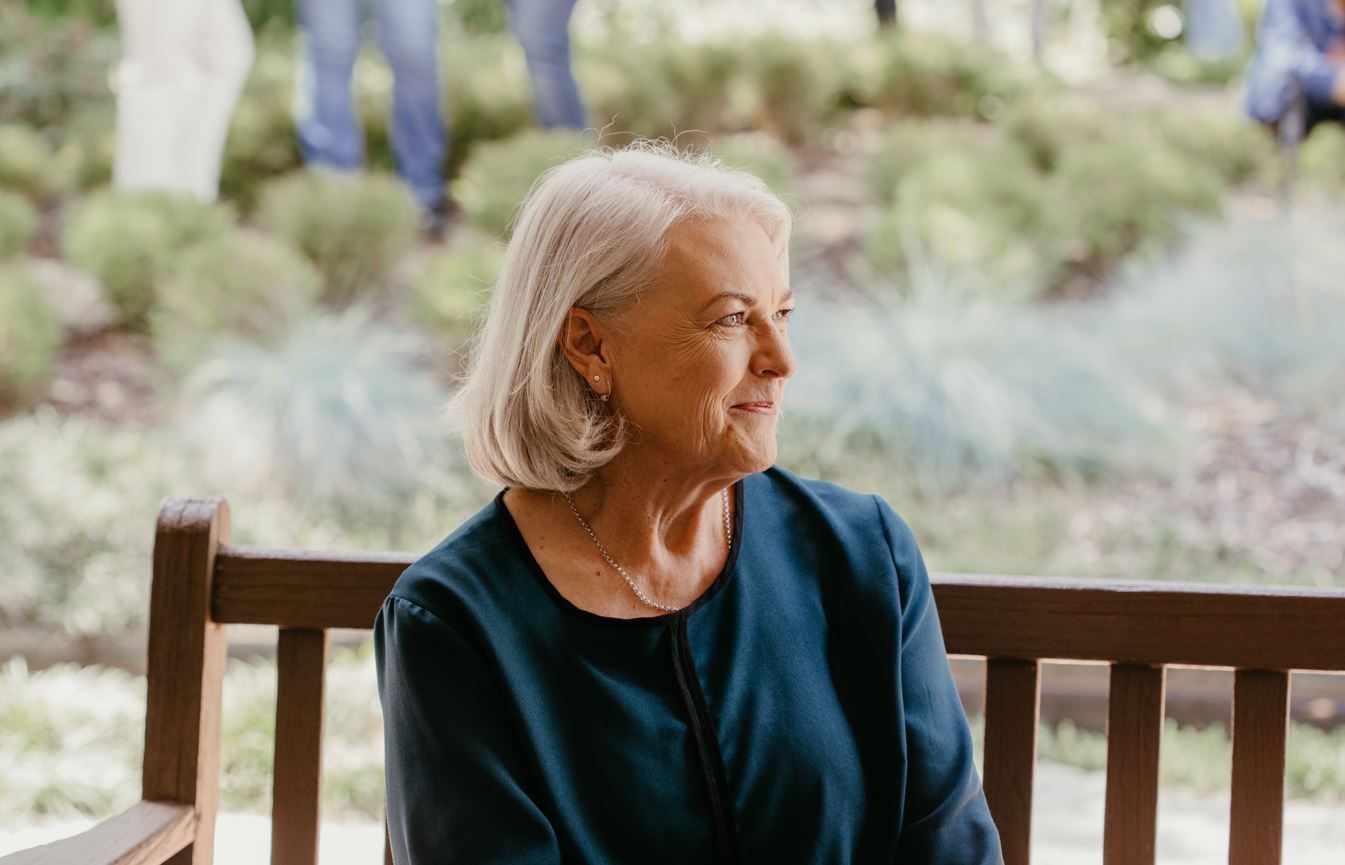 Alison Taylor sits on a bench, smiling off to the side