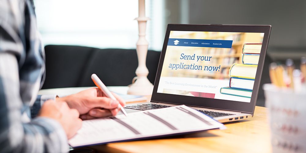 Young man writing college or university application form with pen and paper. Student applying or filling document.Young man writing college or university application form with pen and paper. Student applying or filling document.