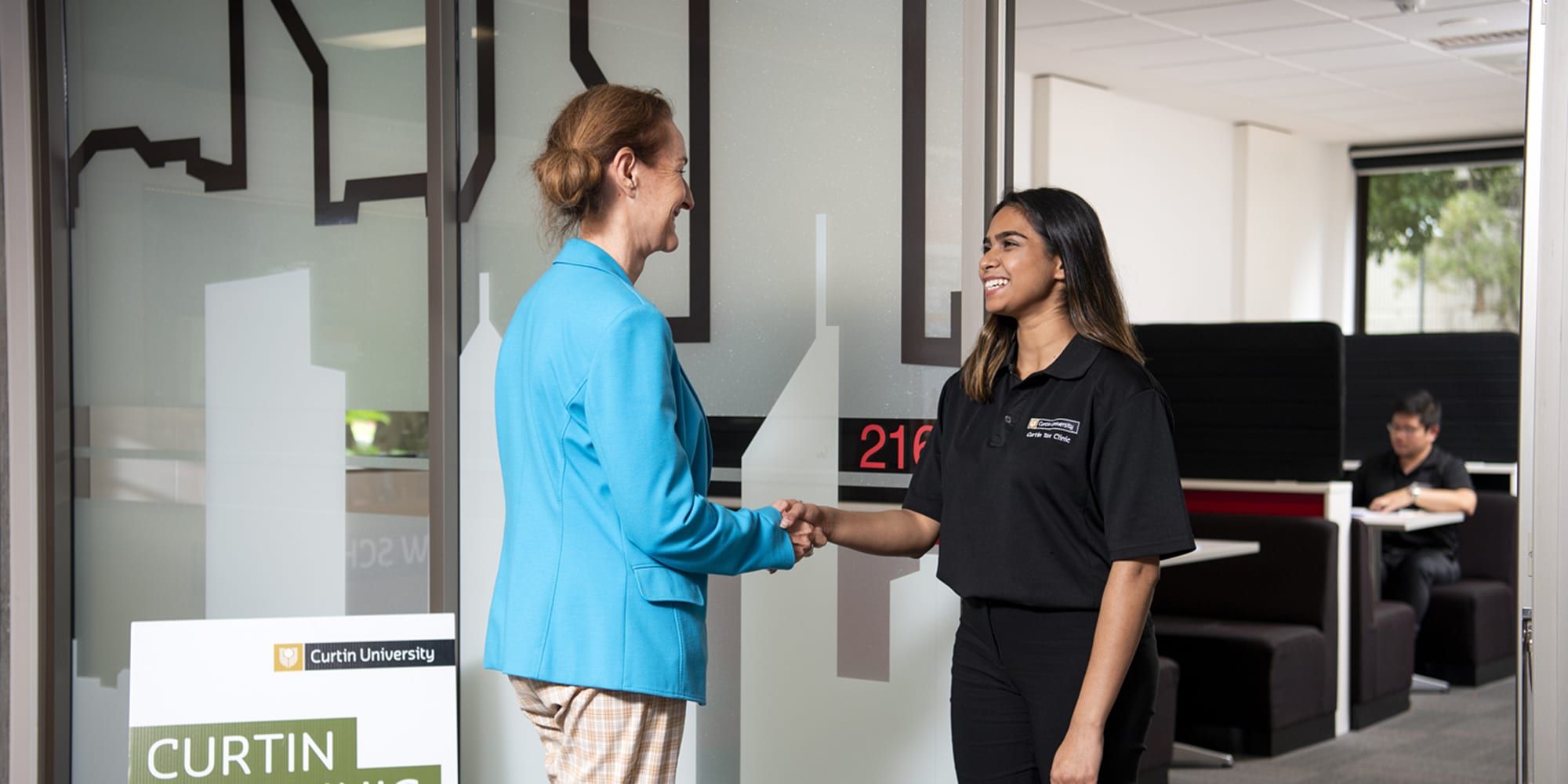 Student greeting a client at the Tax Clinic - play video