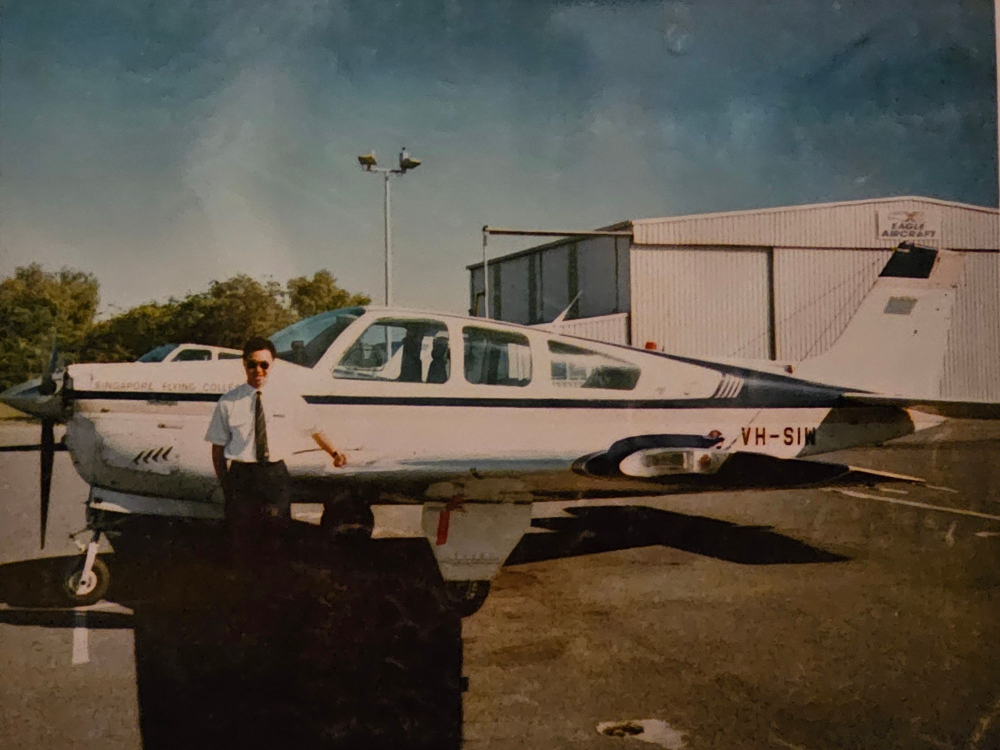 curtin graduate ian cheng standing next to plane