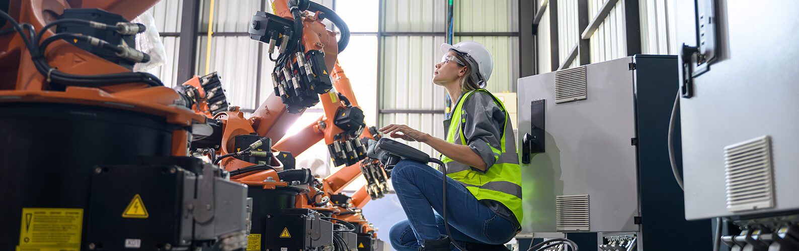 Female engineer working with robotic machine