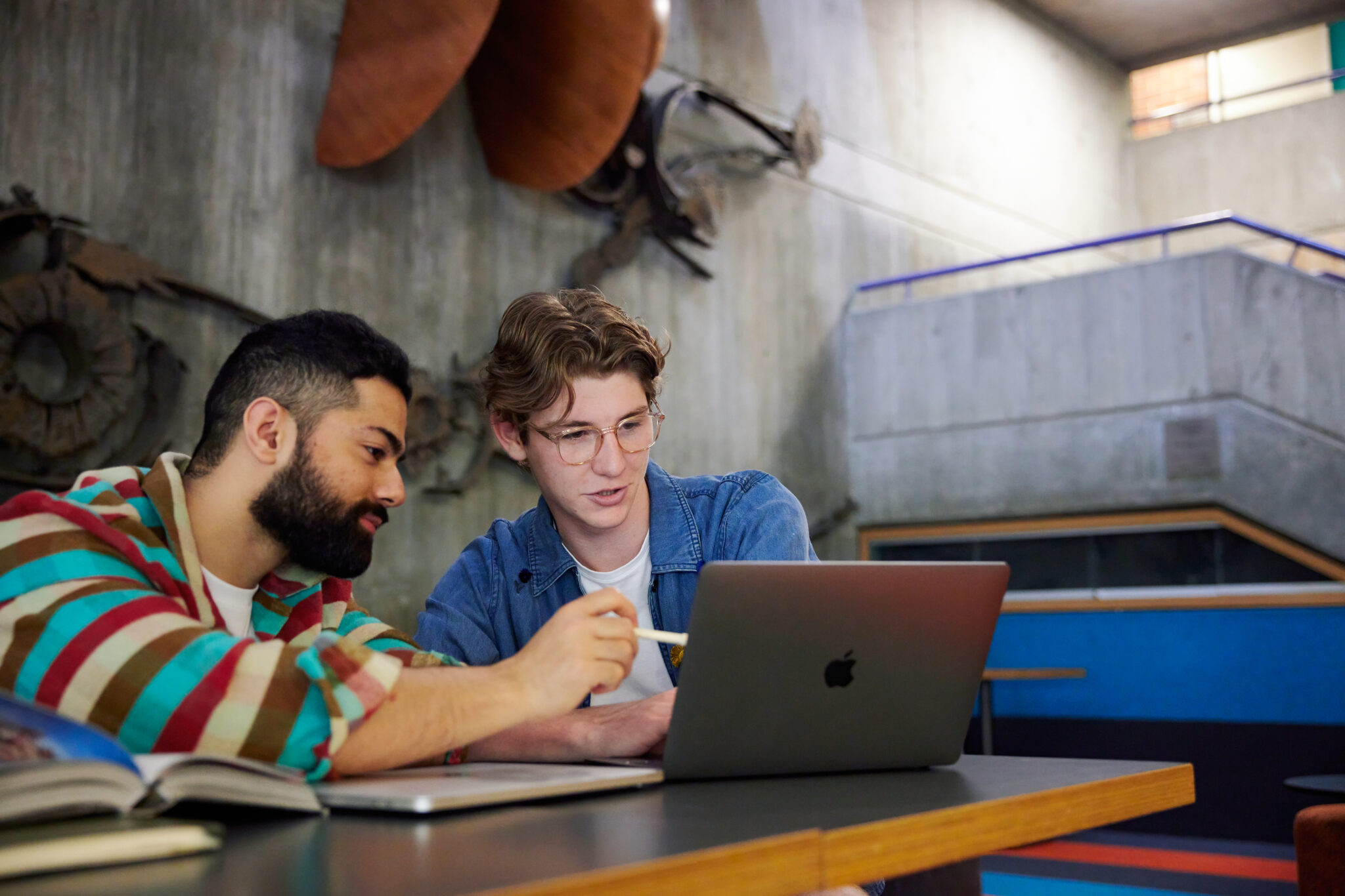 2-students-sitting-together-looking-at-a-laptop