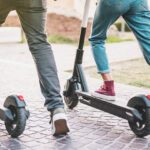 Two people riding e-scooters