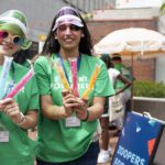 O-Week Volunteers stand with zooper doopers and colourful accessories on during O-Week.