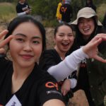 Celena, Devna and a volunteer smiling for the camera.