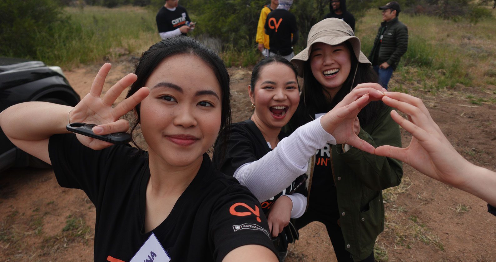 Celena, Devna and a volunteer smiling for the camera.