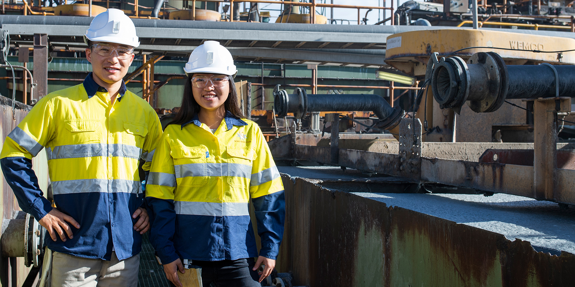 Students wearing hi-vis and hard hats smile on a site in Kalgoorlie