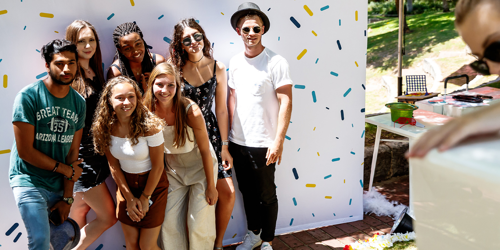 Students stand in front of a white background for a group photo