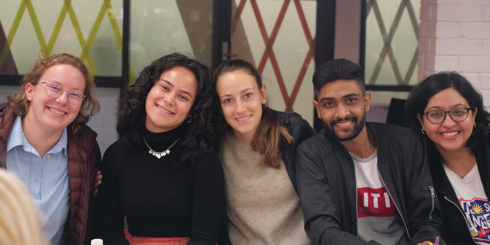 Five students smiling on campus