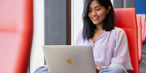 Student looking at a silver laptop