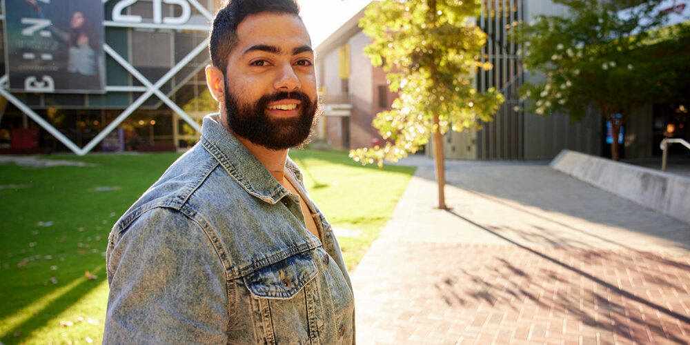 A student on campus smiling at the camera