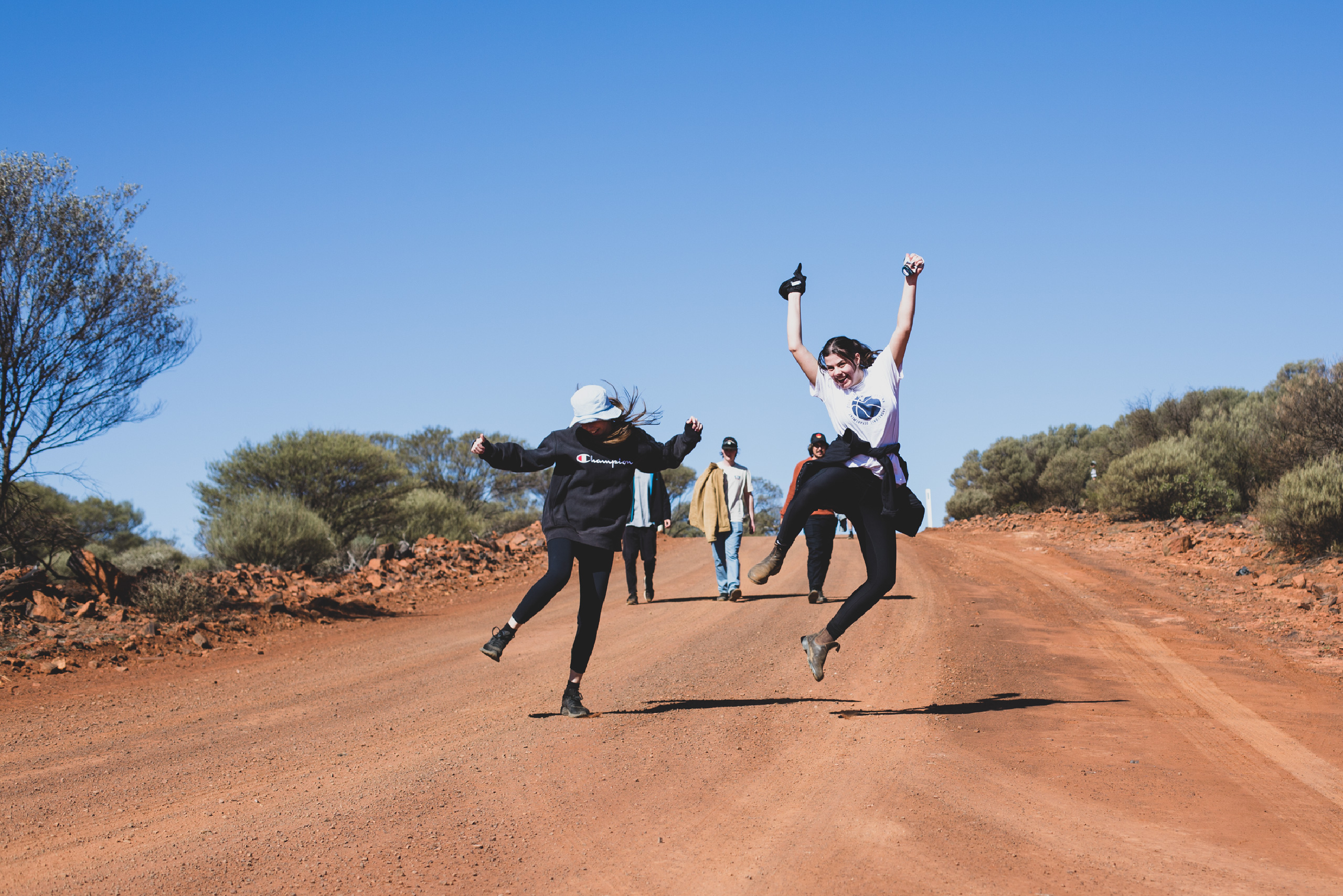 Photograph of a student jumping on a gravel road