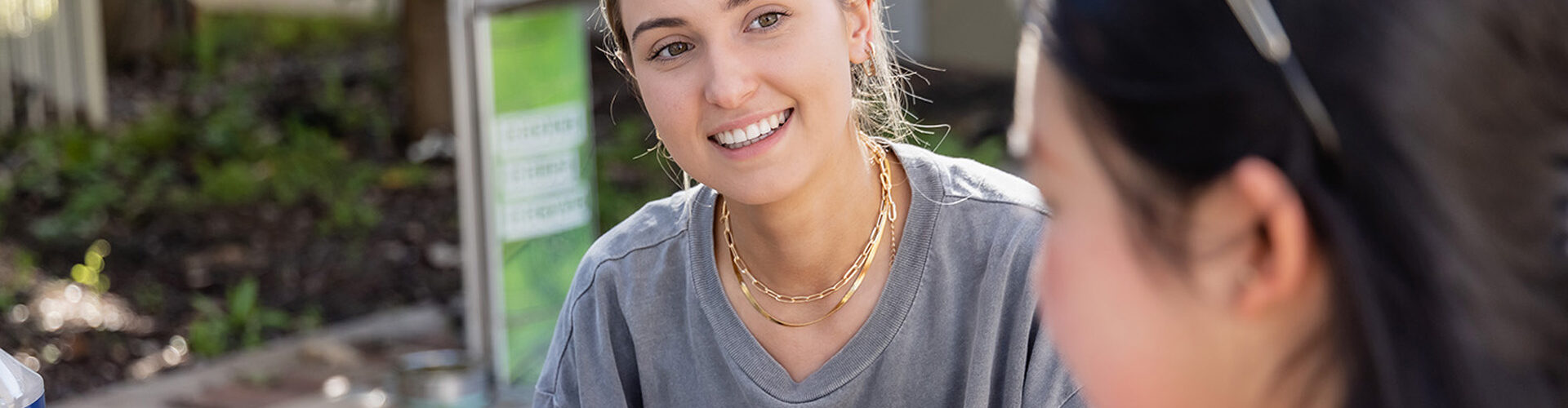 Student smiling to another whilst studying.