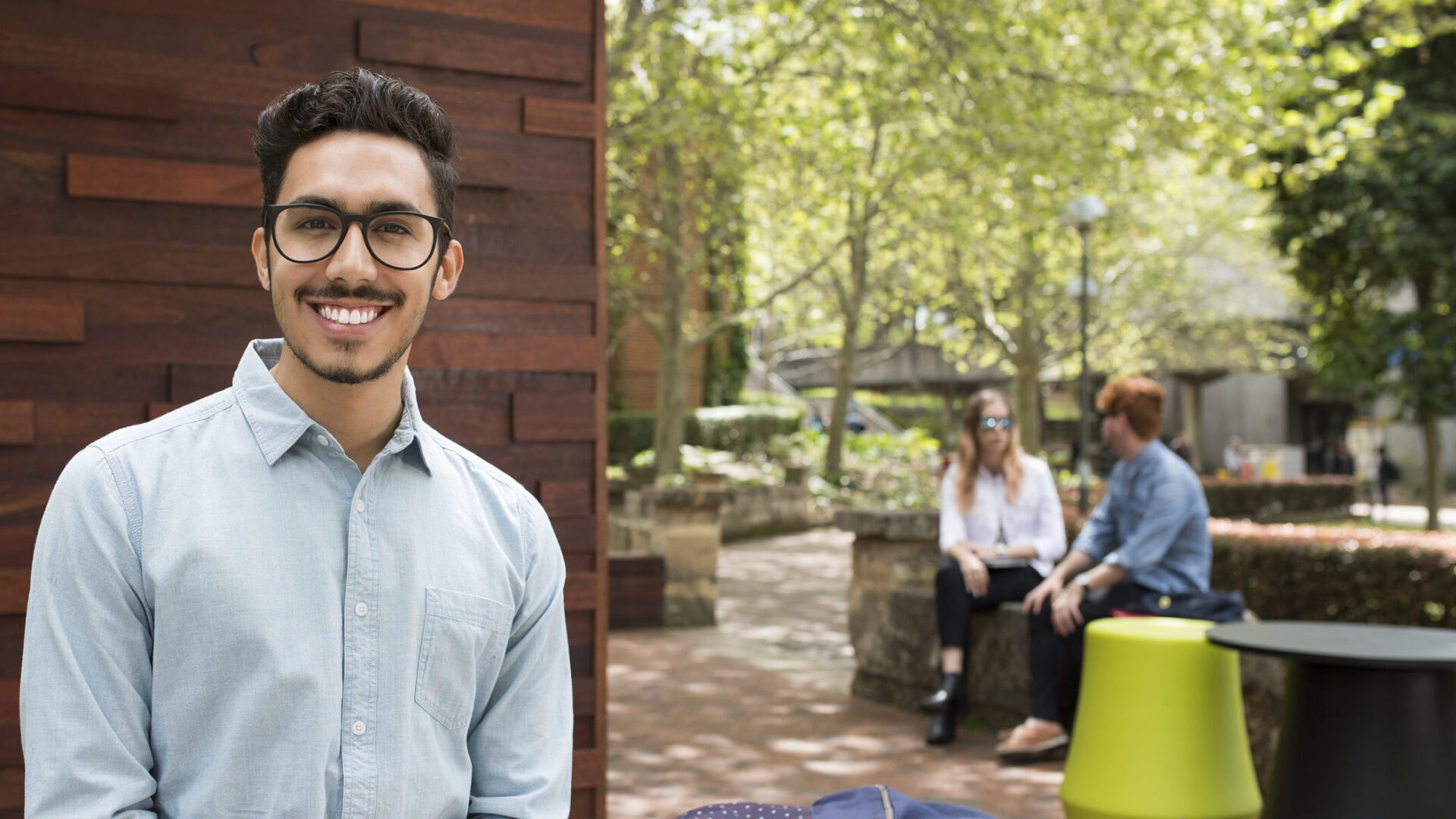 Student smiling on campus near Mallokup