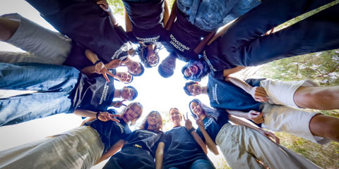 Student Ambassadors in a circle looking down at the camera.