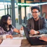 Four students sitting at Westfarmers Court talking