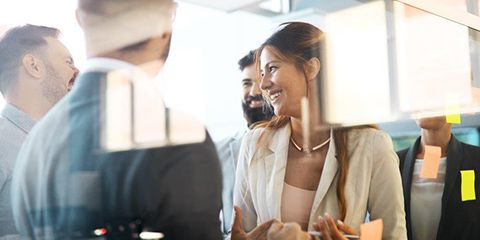 Group of smiling business people behind a window