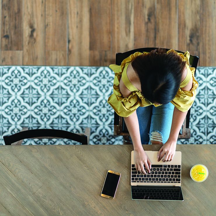 Aerial view of a female at a cafe looking at a laptop