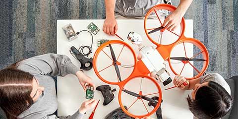 Bird's-eye view of Natalia, Dylan and Liz working together on a drone at Innovation Central Perth