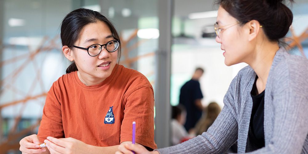 Two students working together in a classroom studying with Curtin English - play video