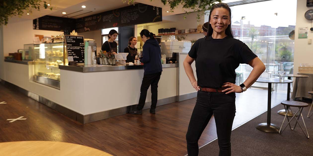 Female Commerce student standing in a cafe setting