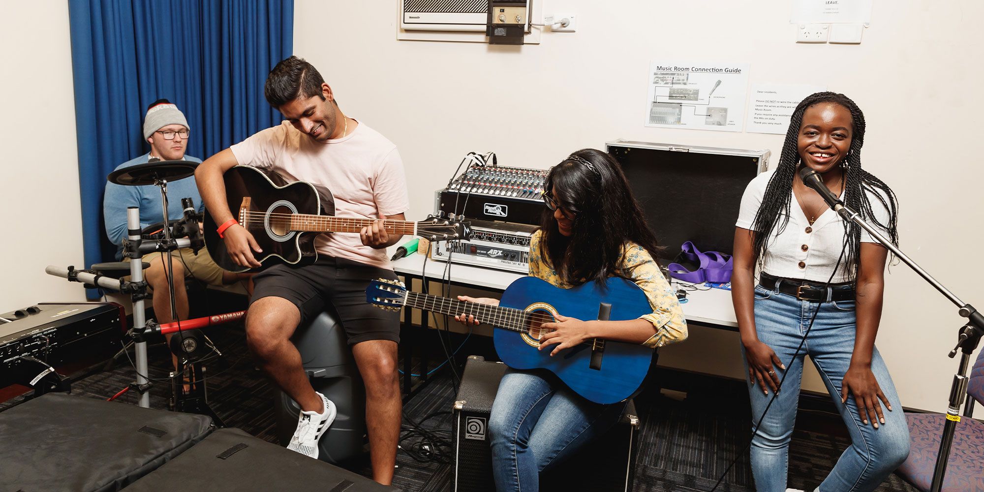 Students playing music together. Guitars, drums, singing.