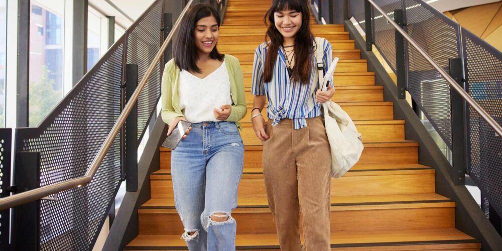 Two female students walking down stairs