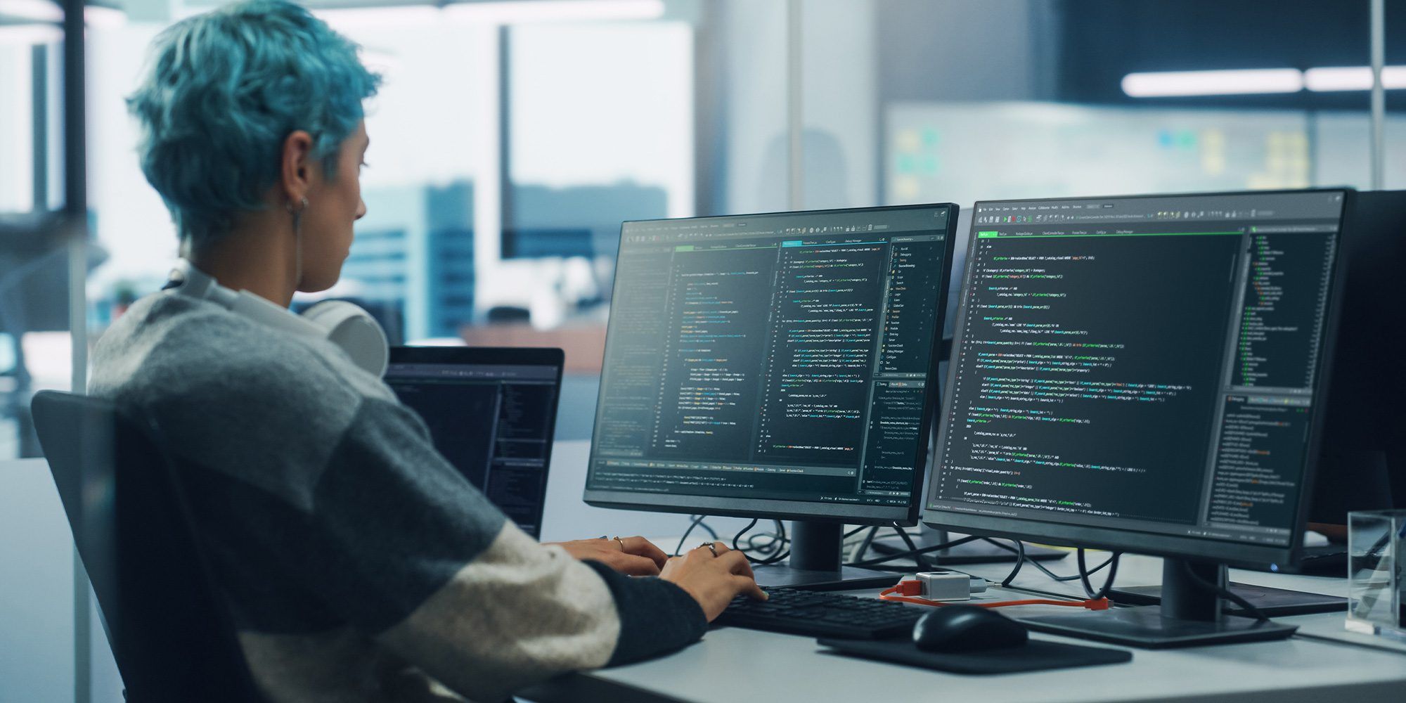 Person looking at code on two computer screens