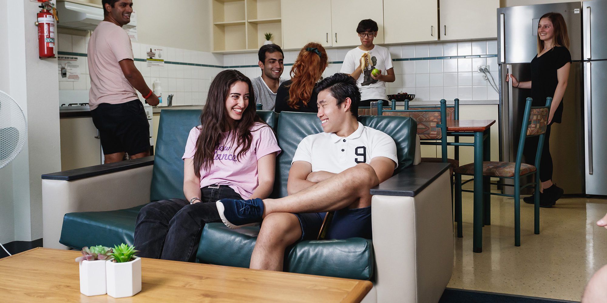 Two students sitting on a couch inside Erica Underwood House