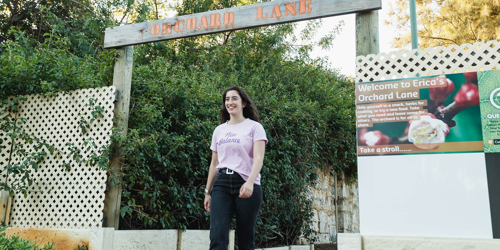 Female student walking in the gardens outside Erica Underwood House