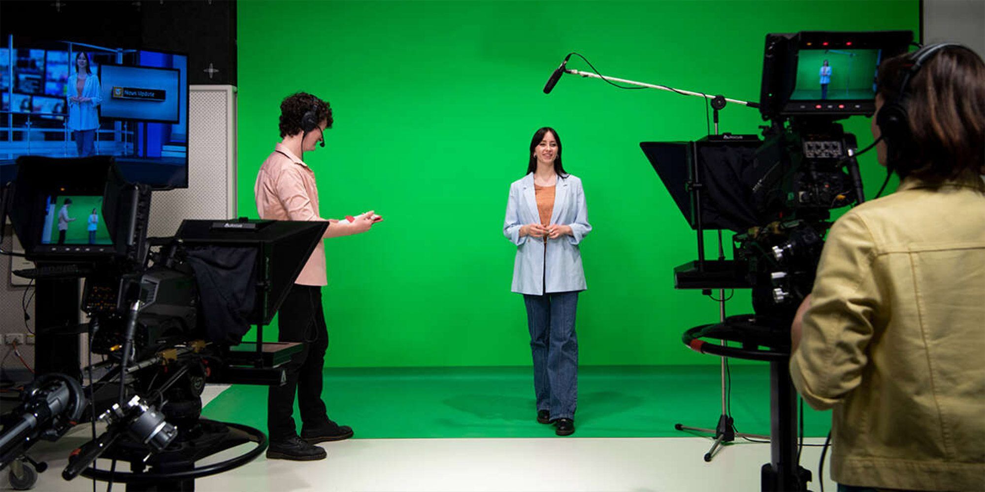 Student standing in front of green screen