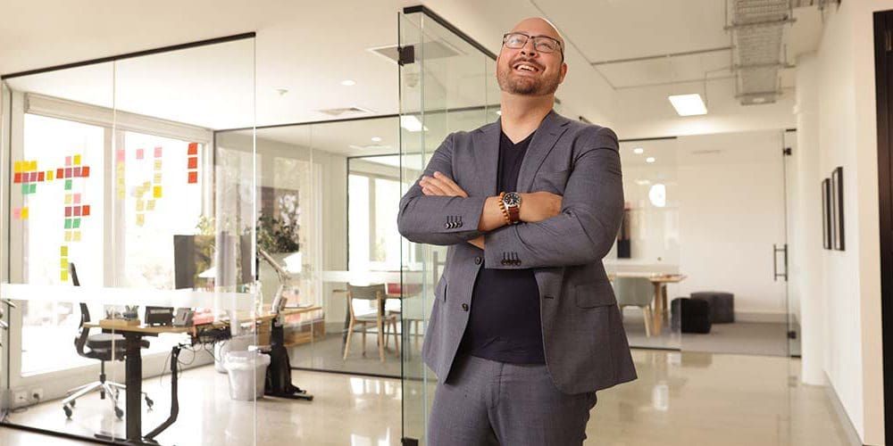 Male Commerce student Andrew standing in an office setting