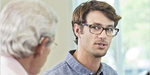 Young male professional wearing glasses, in a conversation