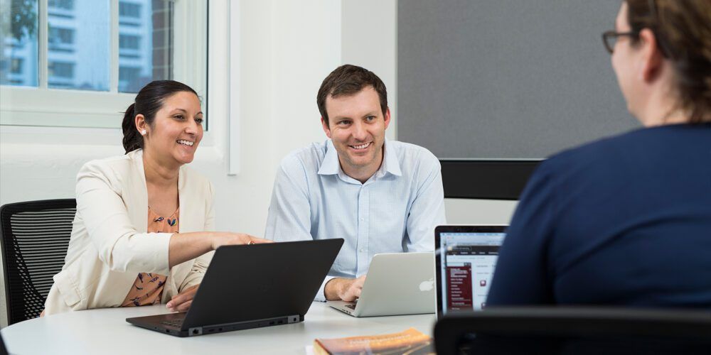 Three people in corporate attire in a meeting. 