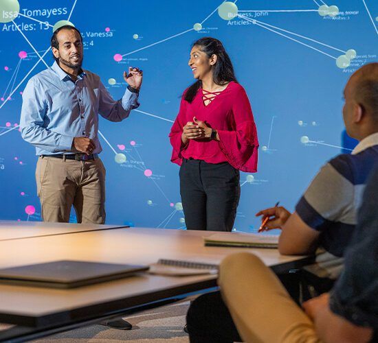 Man and woman presenting data visualisation to class