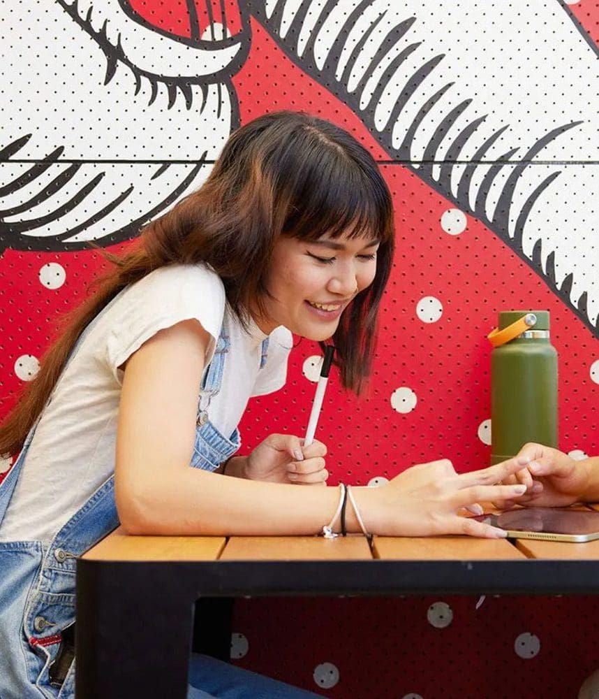 Student sitting at a desk in front of a red background