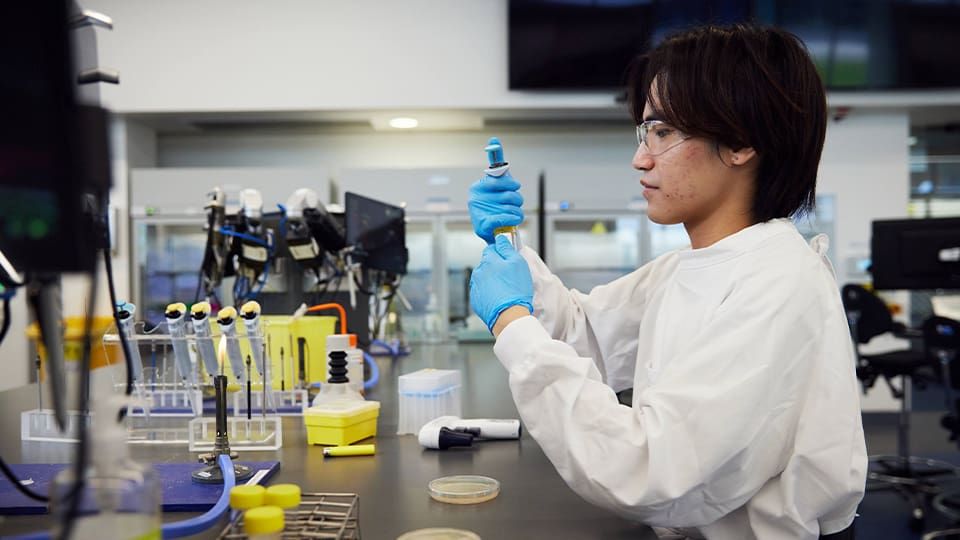 Male student in lab working with test tubes