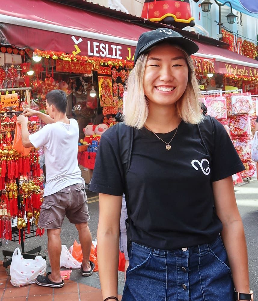 Student in Singapore market, smiling to camera