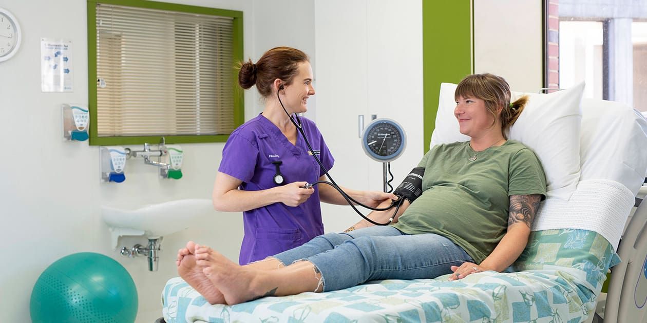 Midwife assessing pregnant woman