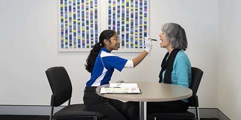 Speech pathology student assessing patient