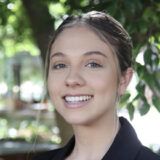 Law graduate Tasmin Cillier standing against green leafy background