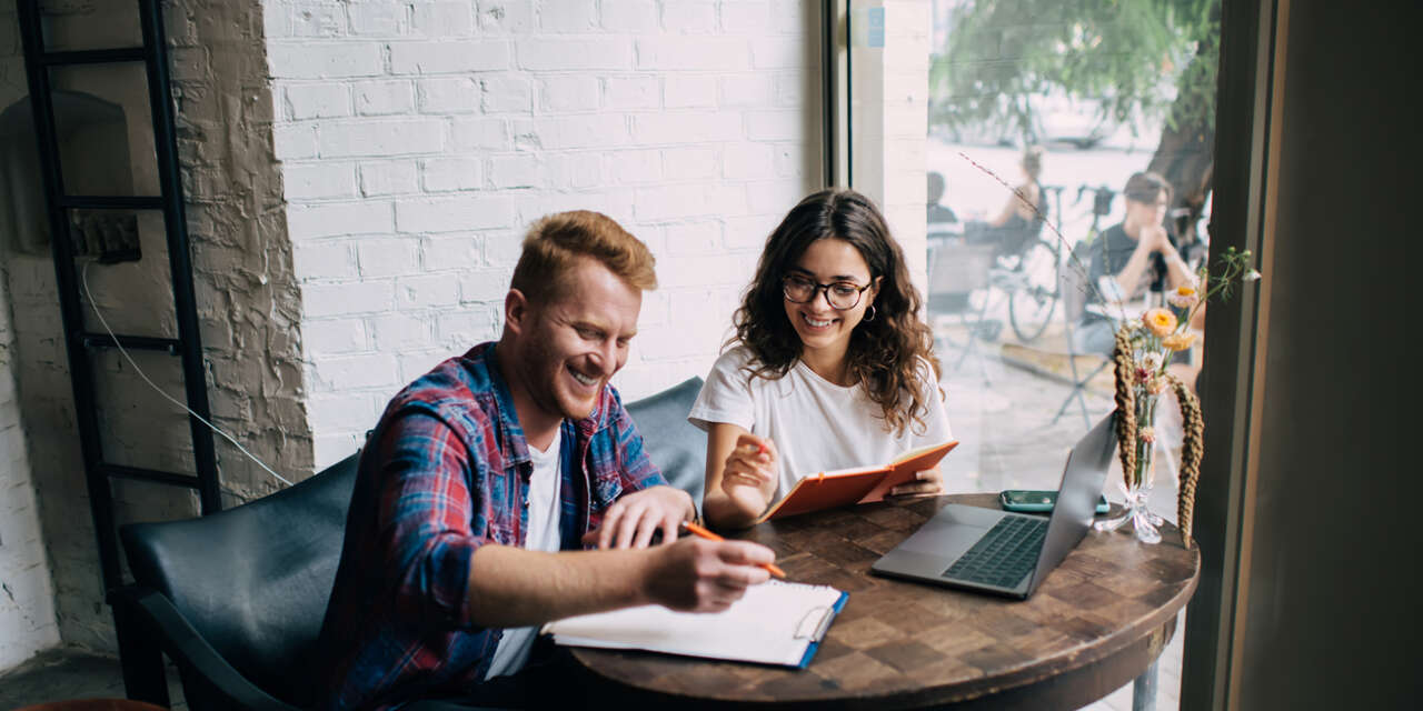 Two students work together in a cafe.