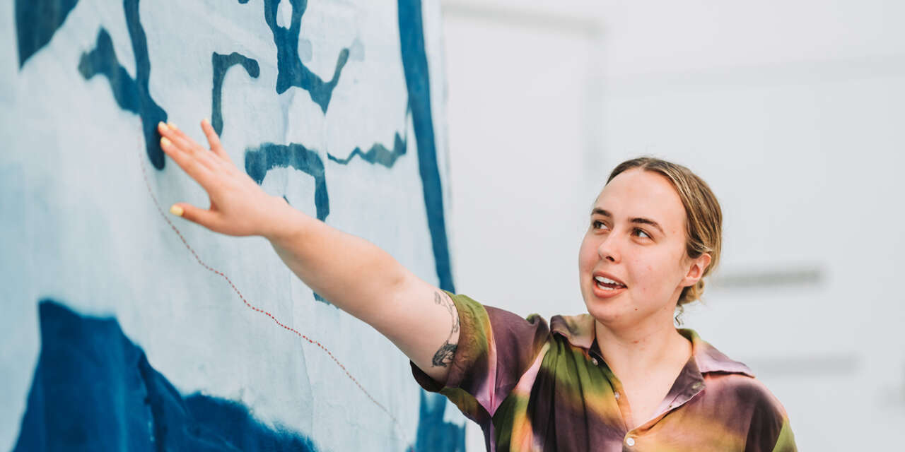 Art lecturer points out an element of a large abstract painting